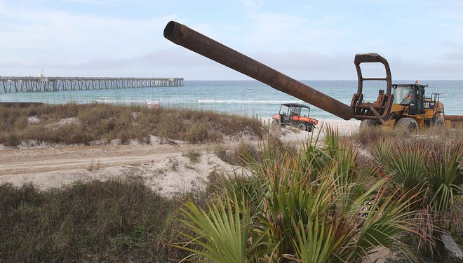 Pipes are moved down to the beach near M.B. Miller County Pier on Monday. The county pier segment of beach renourishment is underway and is slated to be completed April 7. [ANDREW WARDLOW/THE NEWS HERALD]