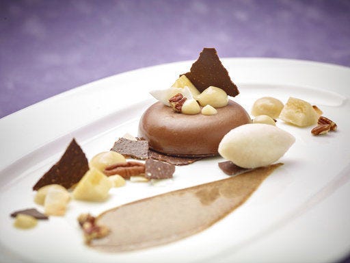 This March 17, 2017 photo provided by The Culinary Institute of America shows the "Three Pleasures" chocolate-banana panna cotta dessert in Hyde Park, N.Y. This dish is from a recipe by the CIA. (Phil Mansfield/The Culinary Institute of America via AP)