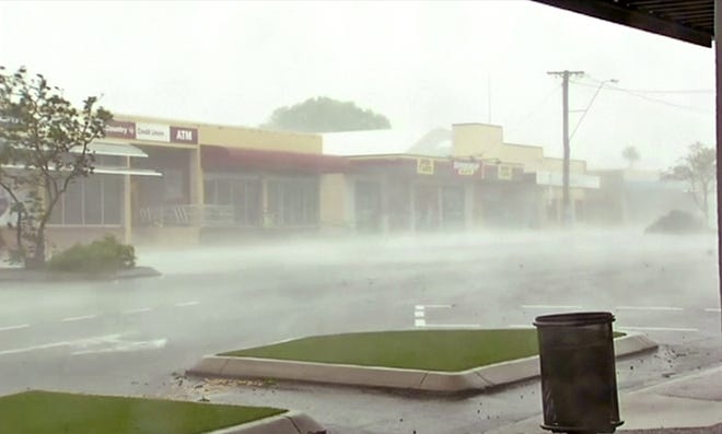 In this image made from video, wind gusts outside shops in Bowen, eastern Australia, Tuesday, March 28, 2017. A powerful cyclone lashed islands, damaged roofs and cut power on Tuesday as it edged toward Australia's tropical northeast coast, officials said. THE ASSOCIATED PRESS