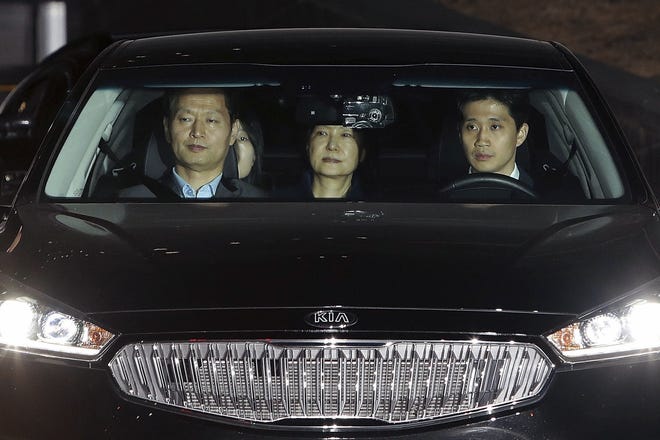 Ousted South Korean President Park Geun-hye, center, leaves the prosecutors' office as she is transferred to a detention house in Seoul, early Friday, March 31, 2017. THE ASSOCIATED PRESS