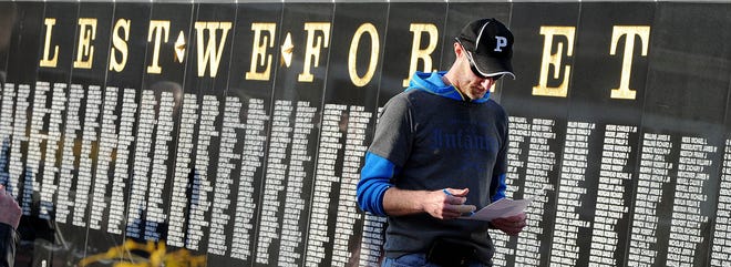 Former U.S. Army Pvt. Eric Moore, of Perry Township, prepares his speech Wednesday prior to the annual Vietnam vigil at the Ohio Veterans' Memorial Park in Clinton. Moore is standing in front of the black granite Vietnam Veterans Memorial Wall. (CantonRep.com / Ray Stewart)