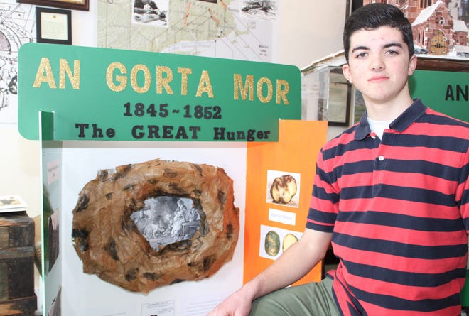 Rogers High School freshman Colin McCabe added a potato to his display on ‘The Great Hunger’ by using newspaper and other art supplies.