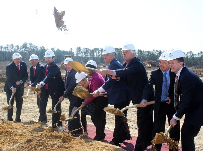 Gov. Terry McAuliffe, alongside state and local officials and company representatives, flings broken ground skyward at a March 24 groundbreaking for Dinwiddie County's new Aldi division headquarters and distribution center. [Sarah Vogelsong/progress-index.com]