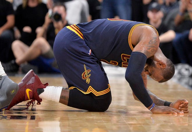 Cleveland Cavaliers forward LeBron James falls to the floor during the second half of an NBA basketball game against the San Antonio Spurs, Monday, March 27, 2017, in San Antonio. (AP Photo/Darren Abate)