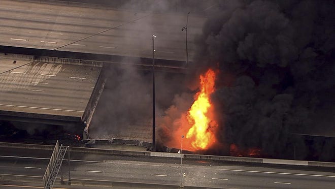 In this aerial image made from a video provided by WSB-TV, a large fire that caused an overpass on Interstate 85 to collapse burns in Atlanta, Thursday, March 30, 2017. Witnesses say troopers were telling cars to turn around on the bridge because they were concerned about its integrity. Minutes later, the bridge collapsed. WSB-TV VIA ASSOCIATED PRESS