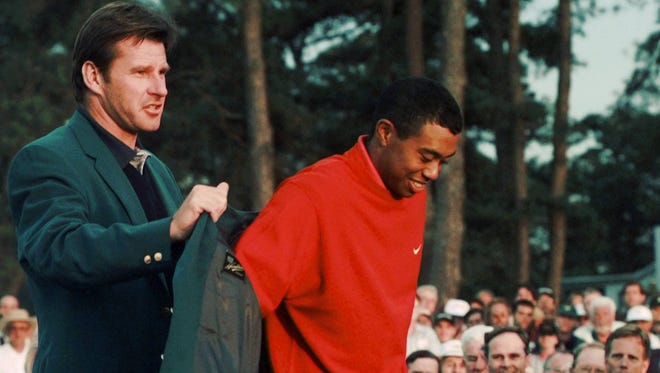1997 Masters champion Tiger Woods receives his Green Jacket from last year’s winner Nick Faldo at the Augusta National Golf Club in Augusta, Ga., Sunday, April 13, 1997. (AP Photo/Amy Sancetta)
