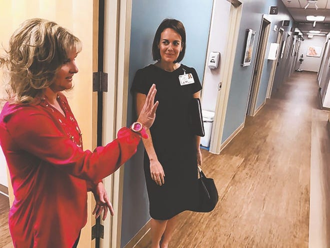 Family Nurse Practitioner Connie Hinnant, left, points out some of the artwork displayed at New Hanover Regional Medical Center Group’s new Jacksonville location to NHRMC Media Coordinator Claire Parker. Photo by Amanda Thames / The Daily News