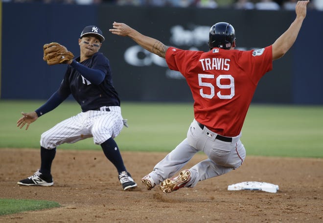 New York Yankees shortstop Ronald Torreyes moves to tag out Boston Red Sox's Sam Travis on a steal attempt during Spring Training. [John Raoux/The Associated Press]