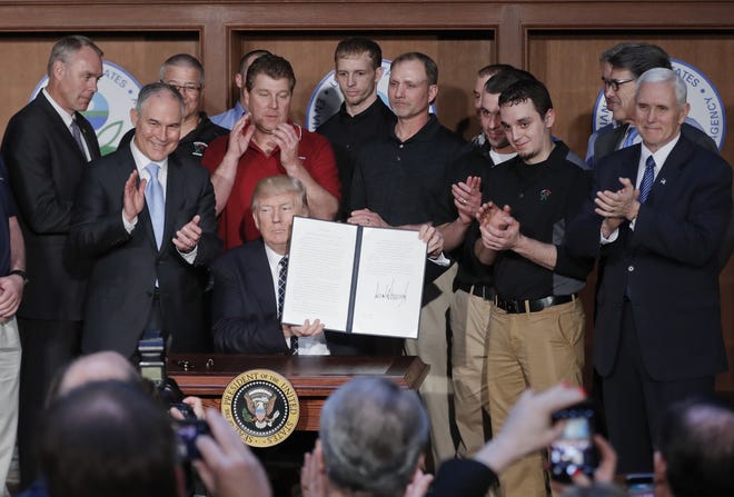 President Donald Trump, accompanied by coal miners and administration officials, holds up the signed Energy Independence Executive Order on Tuesday at Environmental Protection Agency headquarters in Washington. 

AP Photo/Pablo Martinez Monsivais