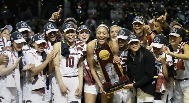 South Carolina forward A'ja Wilson (22) holds the trophy as she and teammates celebrate their win over Mississippi State in the final of NCAA women's Final Four college basketball tournament Sunday in Dallas. South Carolina won 67-55. [TONY GUTIERREZ / ASSOCIATED PRESS]