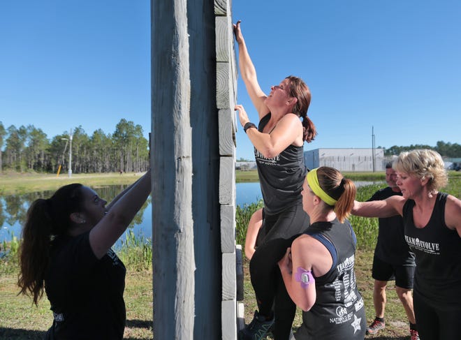 Athletes help a woman climb up a wall on Saturday at the Bay County Jail campus. [Patti Blake | The News Herald]
