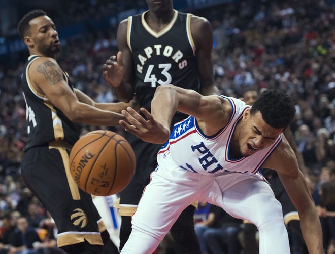 Philadelphia 76ers guard Timothe Luwawu-Cabarrot (20) gets the ball stripped by Toronto Raptors guard Norman Powell, left, during the second half of an NBA basketball game in Toronto on Sunday, April 2, 2017. (Nathan Denette/The Canadian Press via AP)