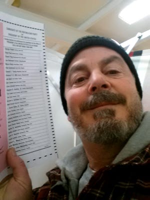 Bill Phillips, of Nashua, N.H., takes a selfie with his marked election ballot on Feb. 9, 2016. [Bill Phillips via AP, file]