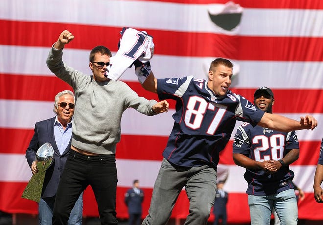 Rob Gronkowski grabs the jersey out of Tom Brady's hands and runs away with it during the pregame ceremony.