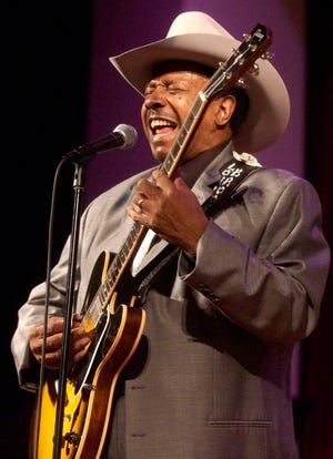 In this Feb. 13, 2005 photo, guitarist Lonnie Brooks performs with the Chicago Jazz Ensemble at the Simpson Theatre in the Field Museum in Chicago. Brooks, whose relationship with his adopted hometown was cemented by his hit recording of Robert Johnson's "Sweet Home Chicago," has died at age 83. (Terrence Antonio James/Chicago Tribune via AP)