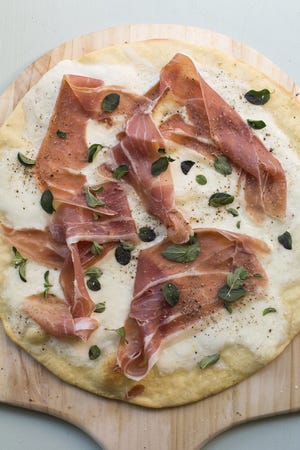 Katie Workman's burrata and prosciutto pizza does not use red sauce so the delicate flavors of the cheese and ham can sbhuine. [Sarah Crowder via Associated Press]