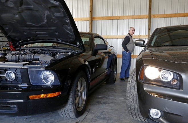 Mount Sterling Mayor Lowell Anderson checks out the Ford Mustang and Dodge Charger that are housed in the Madison County village's garage. They are two of three cars that were bought with more than $700,000 stolen by former village Administrator Joe Johnson, who is serving a prison sentence for the thefts. [Fred Squillante/Dispatch]
