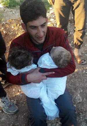 In this picture taken on Tuesday April 4, 2017, Abdul-Hamid Alyousef, 29, cries as he holds his twin babies who were killed during a suspected chemical weapons attack, in Khan Sheikhoun town, in the northern province of Idlib, Syria. Alyousef also lost his wife, two brothers, nephews and many other family members in the attack that claimed scores of his relatives. The death toll from a suspected chemical attack on a northern Syrian town rose to 72 on Wednesday as activists and rescue workers found more terrified survivors hiding in shelters near the site of the harrowing assault, one of the deadliest in Syria's civil war. [ALAA ALYOUSEF via AP]