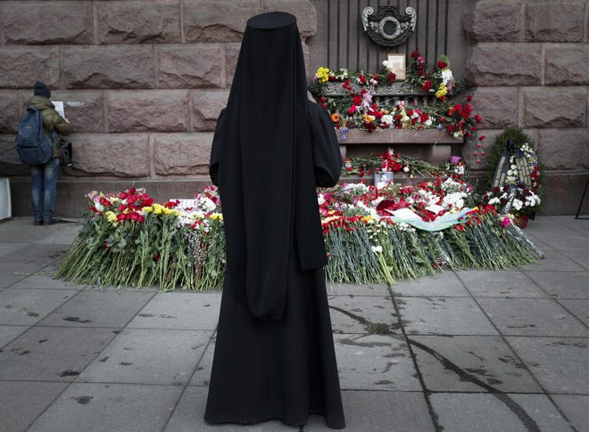 An Orthodox priest stands at a symbolic floral memorial at Technologicheskiy Institute subway station in St. Petersburg, Russia, Tuesday, April 4, 2017. A bomb blast tore through a subway train deep under Russia's second-largest city St. Petersburg Monday, killing several people and wounding many more in a chaotic scene that left victims sprawled on a smoky platform. THE ASSOCIATED PRESS