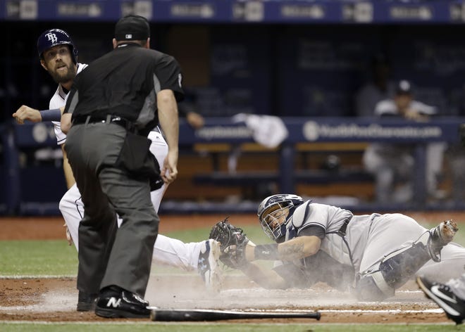 New York Yankees catcher Gary Sanchez tags out Tampa Bay Rays' Steven Souza Jr. as he tries to score on a fielder's choice by Mallex Smith during the second inning Wednesday in St. Petersburg. Making the call is home plate umpire Dan Bellino. [THE ASSOCIATED PRESS / CHRIS O'MEARA]