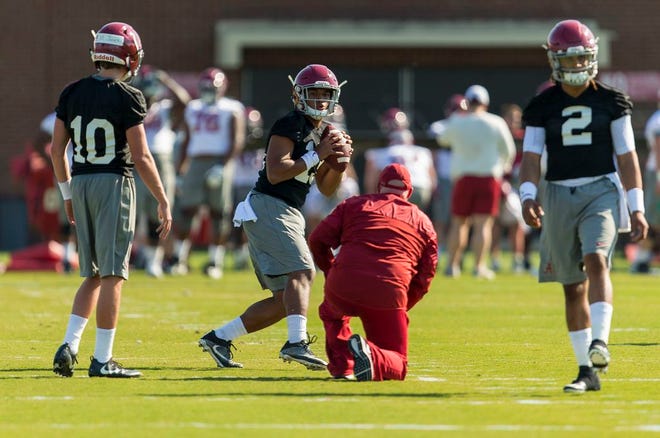 In this March 21, 2017 photo, Alabama quarterbacks Mac Jones (10) Tua Tagovailoa (13) and Jalen Hurts (2) work with offensive coordinator Brian Daboll during a college football spring practice, in Tuscaloosa, Ala. As good as Alabama quarterback Jalen Hurts was as a freshman, he knows he has plenty to improve on this offseason. He's got a new offensive coordinator and two freshmen vying for the backup job. (Vasha Hunt/AL.com via AP)