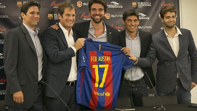 From left, Lance Aldridge, executive director of the Austin Sports Commission; Bobby Epstein, chairman of Circuit of the Americas; Marc Segarra, co-founder of ISL Fútbol; Alex Isern, CEO of ISL Fútbol; and Pipo Sala, director of FCB Escola Texas, show off a customized FC Barcelona jersey Wednesday during a news conference to announce plans for a Barca youth training academy on the grounds of COTA.