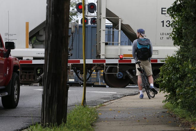 Max Schrader, 19, a University of Alabama student from Waterloo, Ill., waits with his bicycle as two trains pass on Hackberry Road in Tuscaloosa Wednesday April 5, 2017.  [Staff Photo/Erin Nelson]