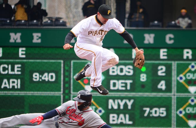 Jordy Mercer jumps to get out of the way of the Braves' Dansby Swanson, who was forced at second base in the eighth inning Friday at PNC Park in Pittsburgh.