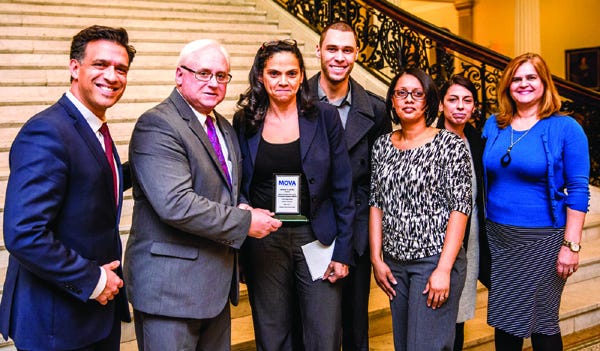 Essex District Attorney Jonathan Blodget presents the “Access to Justice Award” to MAPS Executive Director Paulo Pinto (at left) and staff members.