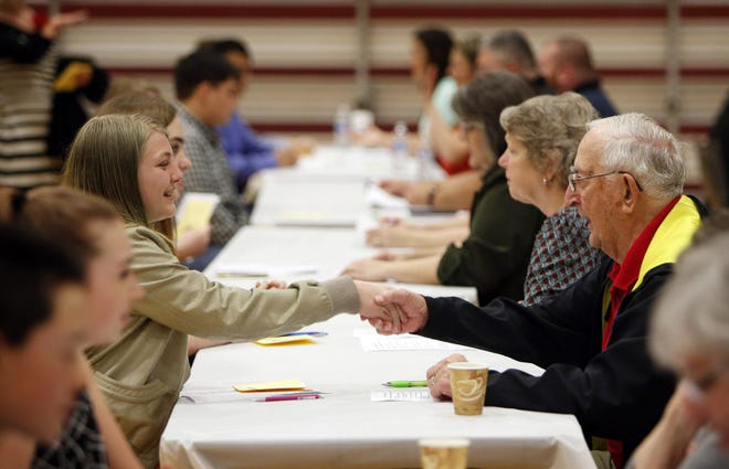 Thurston Middle School student Abby Miller shakes hands with volunteer John Heilbronner before a mock interview during Middle School Career Day at the Bob Keefer Center for Sports and Recreation in Springfield. (Andy Nelson/The Register-Guard)