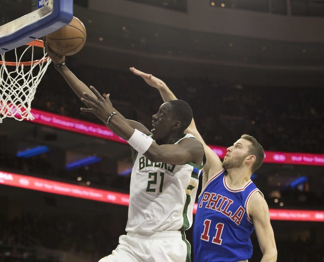 The Bucks' Tony Snell (21) beats the 76ers' Nik Stauskas for a layup during Saturday night's game at the Wells Fargo Center.