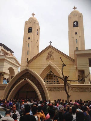Relatives and onlookers gather outside a church after a bomb attack in the Nile Delta town of Tanta, Egypt, Sunday. The attack took place on Palm Sunday, the start of the Holy Week leading up to Easter, when the church in the Nile Delta town of Tanta was packed with worshippers.