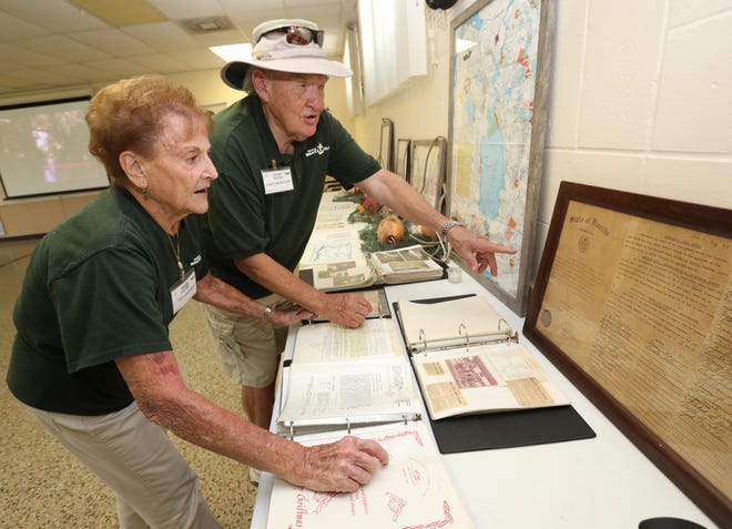 Flo Hoffman and Gary Bergland, who are both members of the Ocala Boat Club, look over the club's original charter that dates back to November 1955, during an open house at the Ocala Boat Club at Ray Wayside Park at the Ocala Boat Basin in Silver Springs on Sunday. [Bruce Ackerman/Staff photographer]