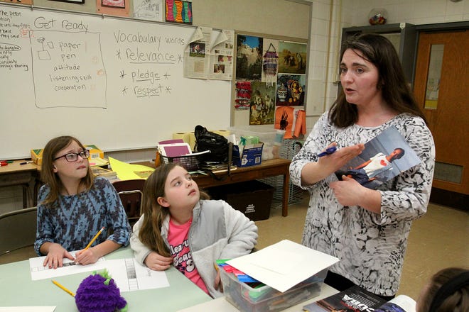 Bailey Jordan (left) and Alyse Cahoon listen to Jennifer Edge from the Monroe Arts Center explain an art project at an after-school class Monday, April 3, 2017, at Orangeville Elementary School in Orangeville. [JANE LETHLEAN/THE JOURNAL-STANDARD CORRESPONDENT]