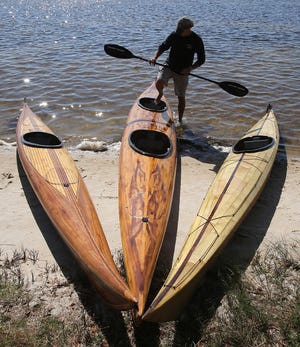 Rob Sanders gets into a custom wood kayak he made in Parker on Monday. Each kayak takes about 400 hours to complete, which equates to about six months of work for Sanders. Watch a related video at newsherald.com. [ANDREW WARDLOW/THE NEWS HERALD]