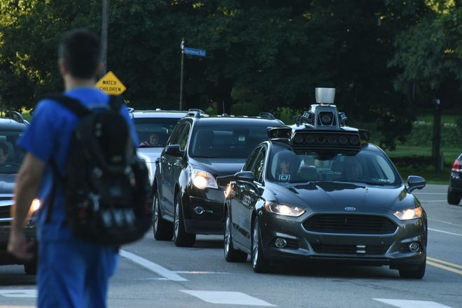 An Uber self-driving Ford Fusion sits at a traffic light as it waits to turn in Pittsburgh. Usage of self-driving vehicles is set to surge in the next two decades, according to a new study. [DARRELL SAPP/PITTSBURG POST-GAZETTE]