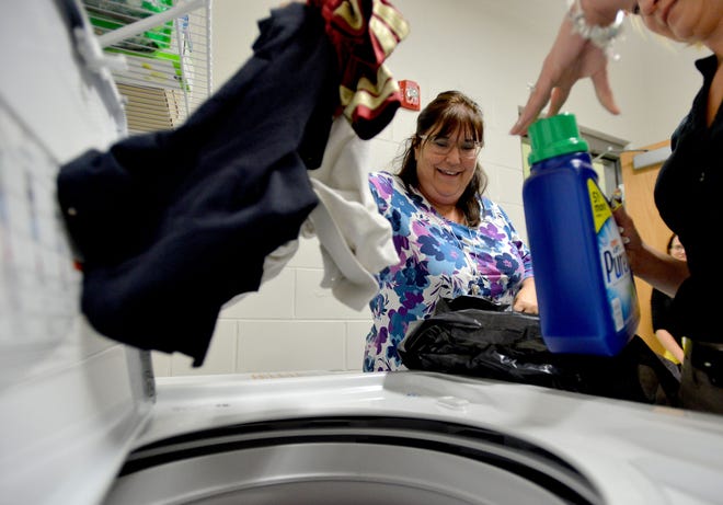 School social worker Sherry Thornton washes a load of laundry at Eustis Heights Elementary School on Monday. In a similar effort in Fairfield, California, washers and dryers were installed in 17 schools. Teachers noticed improved attendance rates, increased motivation among students, greater participation in extracurricular activities. [AMBER RICCINTO / DAILY COMMERCIAL]