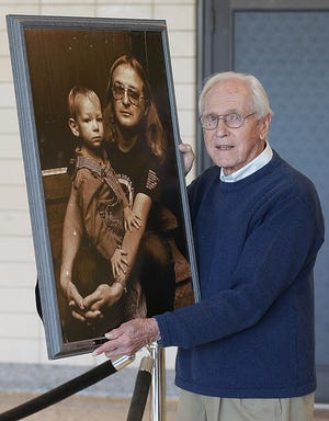 Longtime Stark County educator and retired Perry Local Schools principal Harold Hall holds a photograph of Wade Blank and his son, Lincoln, that has hung in the Perry High School library since 1993.

(IndeOnline.com / Kevin Whitlock)