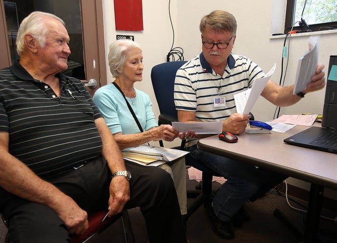 Don and Kay Hammock get their taxes reviewed by Dave Davis at the Volunteer Income Tax Assistance (VITA) site at the A.D. Harris Learning Village in Panama City on Monday. [ANDREW WARDLOW/THE NEWS HERALD]