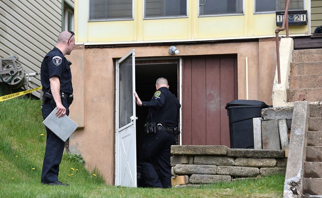 Police enter through a basement door to a home at 1321 Fourth Ave. in Conway after a shooting there Tuesday.