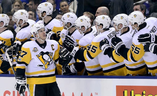 Penguins center Sidney Crosby (87) gets congratulations on his goal against the Toronto Maple Leafs during the second period of an NHL hockey game on April 8 in Toronto.