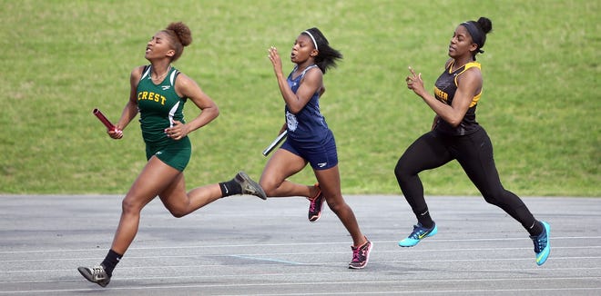 Crest's Niyya Green pulls out ahead in the 4x2 relay as Burns' Kamri Huskey and Kings Mountain's Kamyiah Pressley follow close behind during a county track meet at Kings Mountain High School on Wednesday. [Brittany Randolph/The Star]