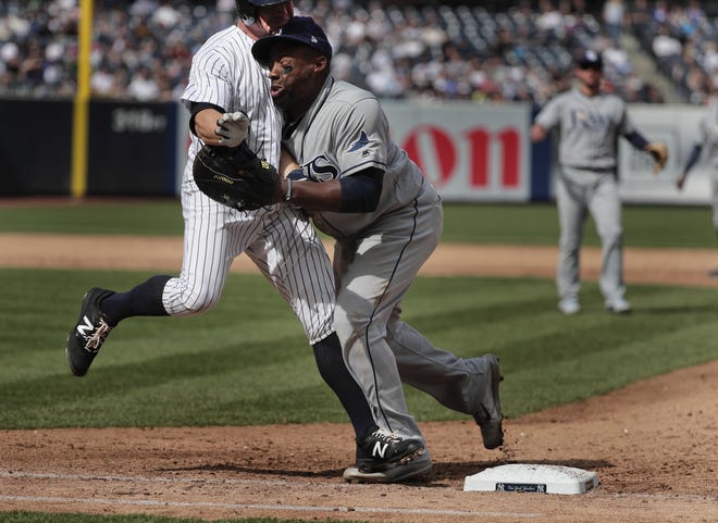 New York Yankees' Brett Gardner, left, collides with Tampa Bay Rays first baseman Rickie Weeks as Weeks reaches for an errant throw by pitcher Xavier Cedeno during the sixth inning Wednesday in New York. Chase Headley scored on the play. Both Weeks and Gardn1er left the game. [THE ASSOCIATED PRESS / JULIE JACOBSON]