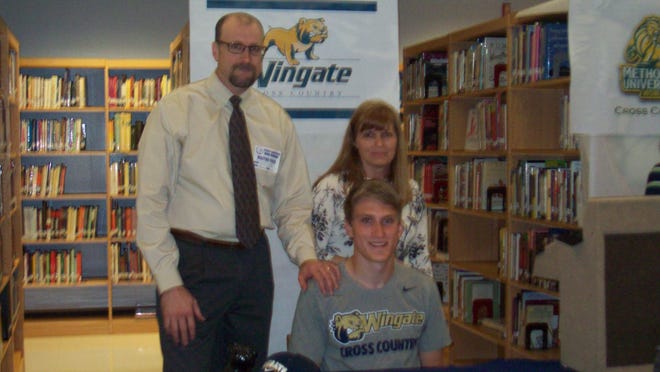 Terry Sanford senior Devon Pratt, seated in front of his parents, Shannon and Clarice Pratt, signed to run cross country for Wingate at the high school on April 12, 2017. [Contributed photo]