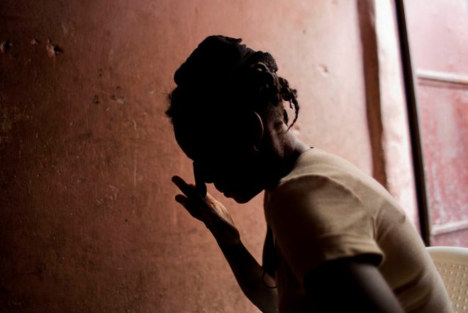 In this Aug. 11, 2016 photo, Martine Gestime 32, wipes her tears during an interview in Port-au-Prince, Haiti. Gestime said she was raped by a Brazilian peacekeeper in 2008 and became pregnant with her son, Ashford. Unable to afford school for him, she relies on him to beg for food. "He tells me all the time that he doesn't have a father or mother who can look after him." (AP Photo/Dieu Nalio Chery)