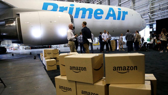 Amazon.com boxes are shown stacked near a Boeing 767 Amazon “Prime Air” cargo plane on display in a Boeing hangar in Seattle. (Associated Press)