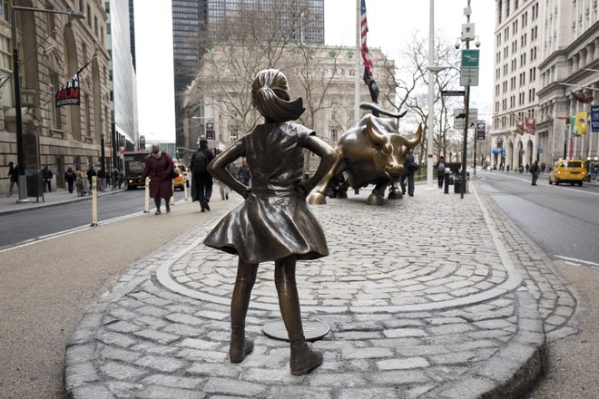In this March 8, 2017, photo, the "Fearless Girl" statue faces Wall Street's charging bull statue in New York. The sculptor of Wall Street's "Charging Bull" says New York City is violating his legal rights by forcing his bronze beast to face off against the "Fearless Girl." Artist Arturo Di Modica said Wednesday, April 12, 2017, that the new neighboring statue changes his bull into something negative. THE ASSOCIATED PRESS