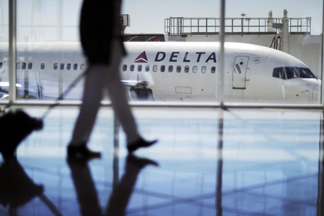 In this Oct. 13, 2016, file photo, a Delta Air Lines jet sits at a gate at Hartsfield-Jackson Atlanta International Airport in Atlanta. Delta says it has empowered employees to offer up to $9,950 to passengers who are willing to give up their seats on overbooked flights. THE ASSOCIATED PRESS