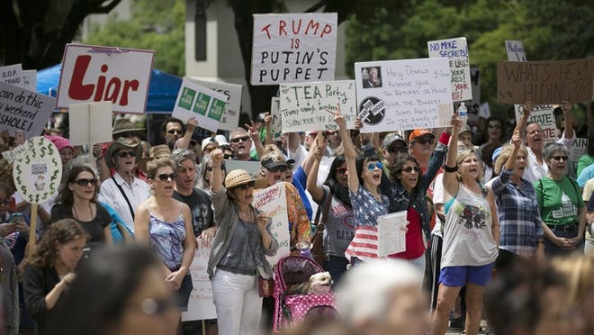 People wave signs and yell Saturday as they listen to a speaker during a protest calling for President Donald Trump to release his tax returns. The protest at the state Capitol was part of a series of marches and protests happening throughout the country. DEBORAH CANNON/AMERICAN-STATESMAN