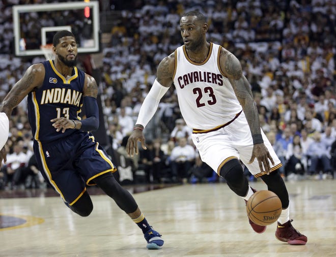 Cleveland Cavaliers' LeBron James (23) drives past Indiana Pacers' Paul George (13) in the first half in Game 1 of a first-round NBA playoff series on Saturday. James scored 32 points, and the Cavs won 109-108. (AP Photo/Tony Dejak)